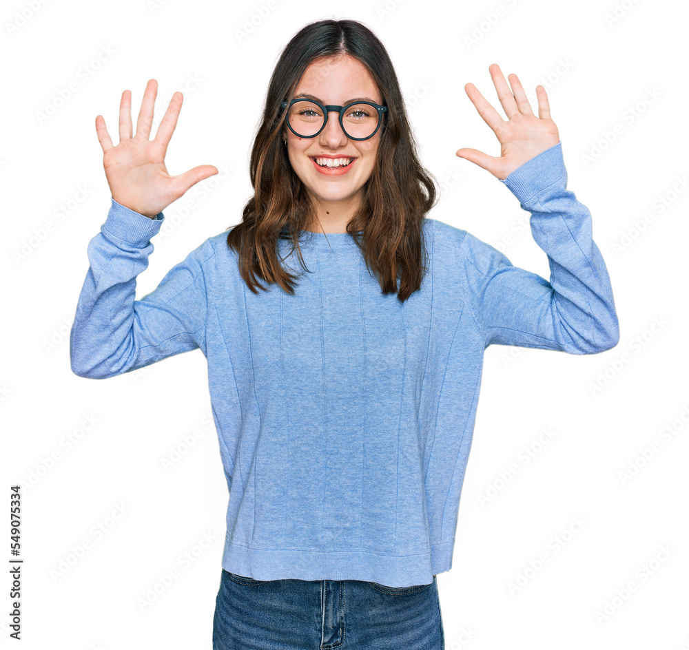 Young beautiful woman wearing casual clothes and glasses showing and pointing up with fingers number ten while smiling confident and happy. Young beautiful woman wearing casual clothes and glasses showing and pointing up with fingers number ten while smiling confident and happy.