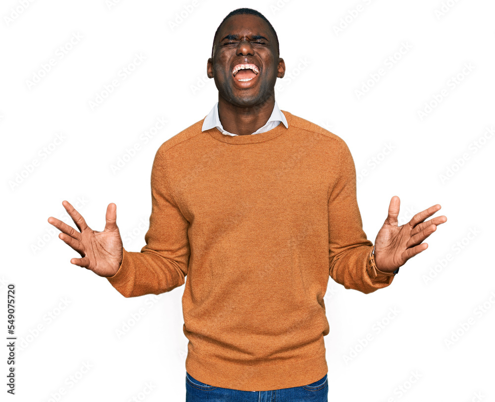 Young african american man wearing casual clothes celebrating mad and crazy for success with arms raised and closed eyes screaming excited. winner concept Young african american man wearing casual clothes celebrating mad and crazy for success with arms raised and closed eyes screaming excited. winner concept