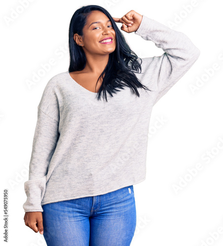 Hispanic woman with long hair wearing casual clothes smiling pointing to head with one finger, great idea or thought, good memory