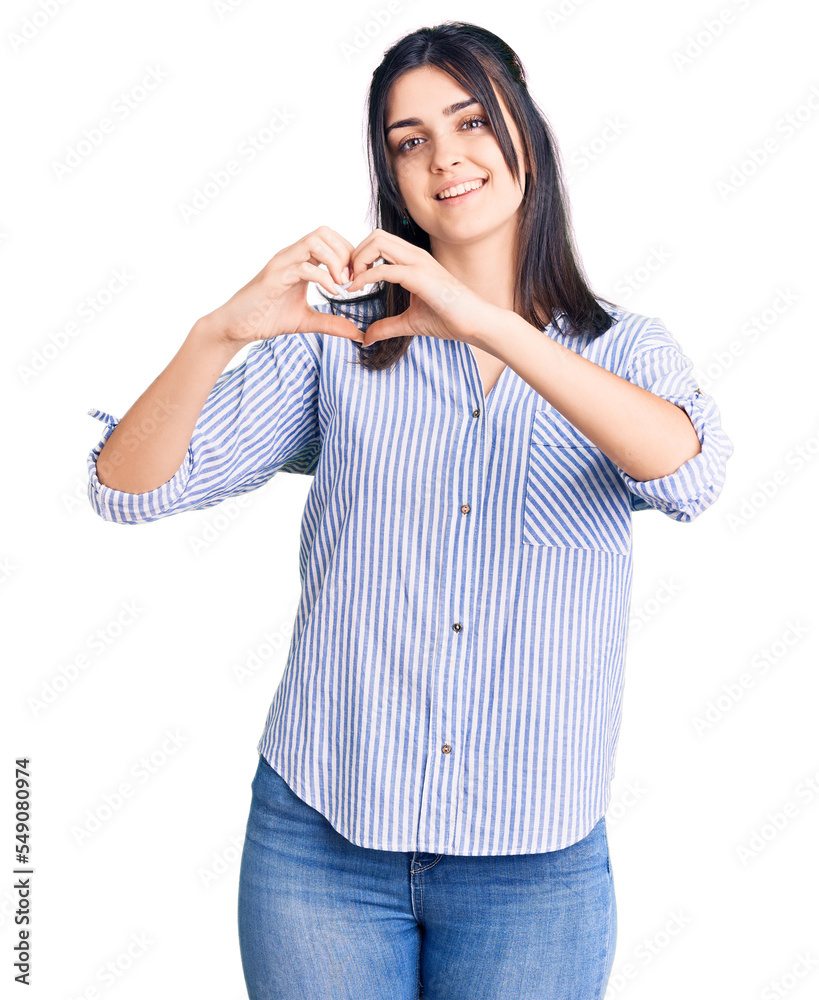 Young beautiful girl wearing striped shirt smiling in love showing heart symbol and shape with hands. romantic concept.