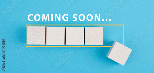 Coming soon is standing over a loading bar, hand puts the last cube, new arrival, promotion concept photo