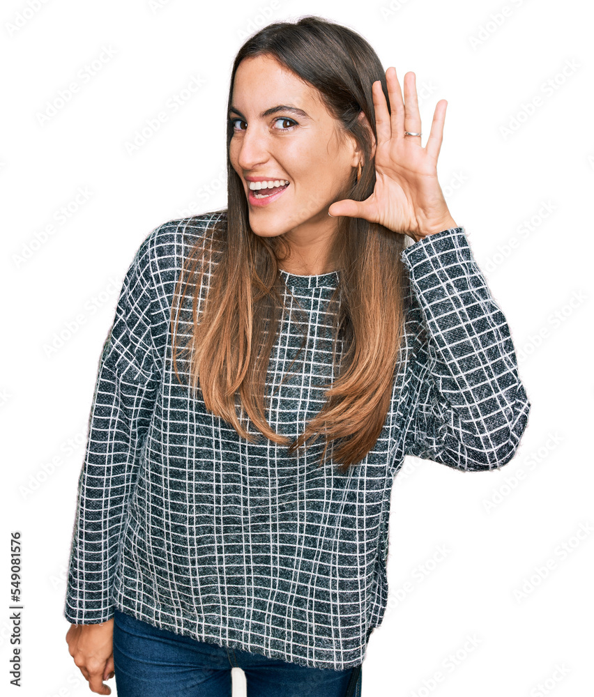 Young beautiful woman wearing casual clothes smiling with hand over ear listening an hearing to rumor or gossip. deafness concept. Young beautiful woman wearing casual clothes smiling with hand over ear listening an hearing to rumor or gossip. deafness concept.
