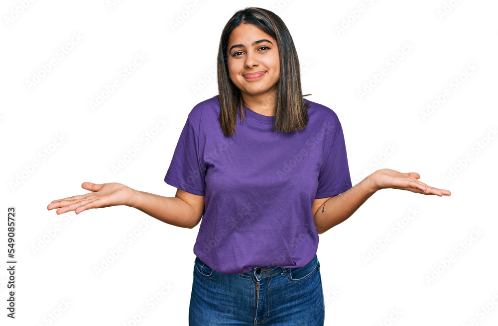 Young hispanic girl wearing casual purple t shirt clueless and confused expression with arms and hands raised. doubt concept. Young hispanic girl wearing casual purple t shirt clueless and confused expression with arms and hands raised. doubt concept.