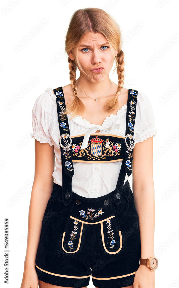 Young beautiful blonde woman wearing oktoberfest dress depressed and worry for distress, crying angry and afraid. sad expression. Young beautiful blonde woman wearing oktoberfest dress depressed and worry for distress, crying angry and afraid. sad expression.