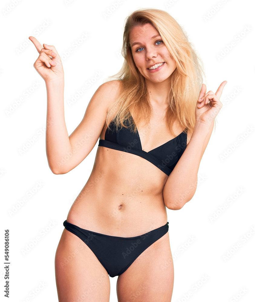 Young beautiful blonde woman wearing bikini smiling confident pointing with fingers to different directions. copy space for advertisement Young beautiful blonde woman wearing bikini smiling confident pointing with fingers to different directions. copy space for advertisement