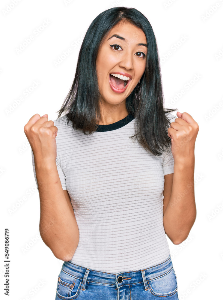 Beautiful asian young woman wearing casual white t shirt celebrating surprised and amazed for success with arms raised and open eyes. winner concept. Beautiful asian young woman wearing casual white t shirt celebrating surprised and amazed for success with arms raised and open eyes. winner concept.