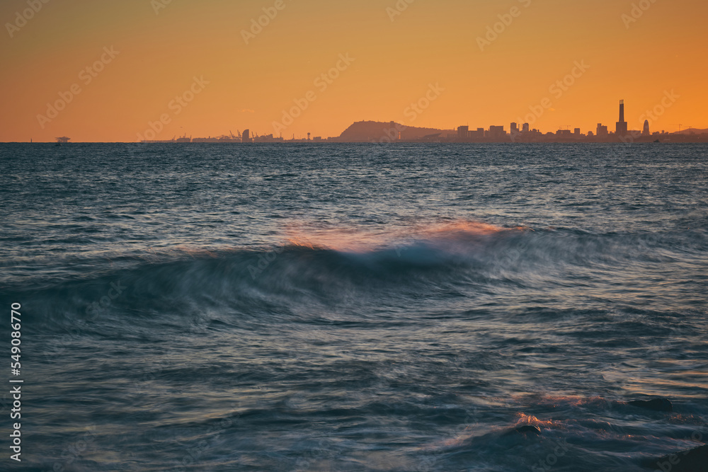 Atardecer en el mar con la ciudad de Barcelona de fondo Atardecer en el mar con la ciudad de Barcelona de fondo