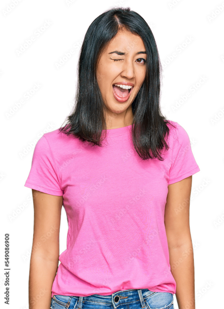 Beautiful asian young woman wearing casual pink t shirt winking looking at the camera with sexy expression, cheerful and happy face. Beautiful asian young woman wearing casual pink t shirt winking looking at the camera with sexy expression, cheerful and happy face.