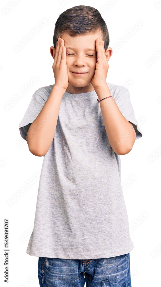 Cute blond kid wearing casual clothes suffering from headache desperate and stressed because pain and migraine. hands on head. Cute blond kid wearing casual clothes suffering from headache desperate and stressed because pain and migraine. hands on head.