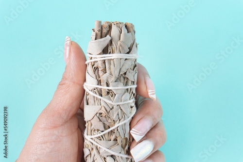 Hand holding white sage for incense photo