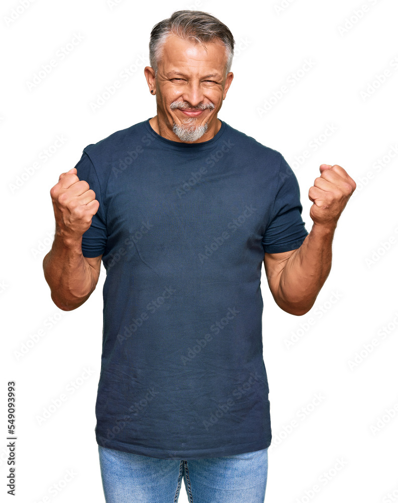 Middle age grey-haired man wearing casual clothes excited for success with arms raised and eyes closed celebrating victory smiling. winner concept. Middle age grey-haired man wearing casual clothes excited for success with arms raised and eyes closed celebrating victory smiling. winner concept.