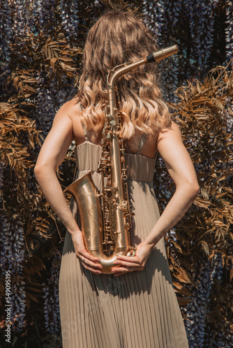 Girl with saxophones in nature   jazz music 