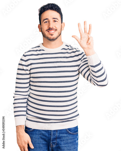 Young hispanic man wearing casual clothes showing and pointing up with fingers number four while smiling confident and happy.