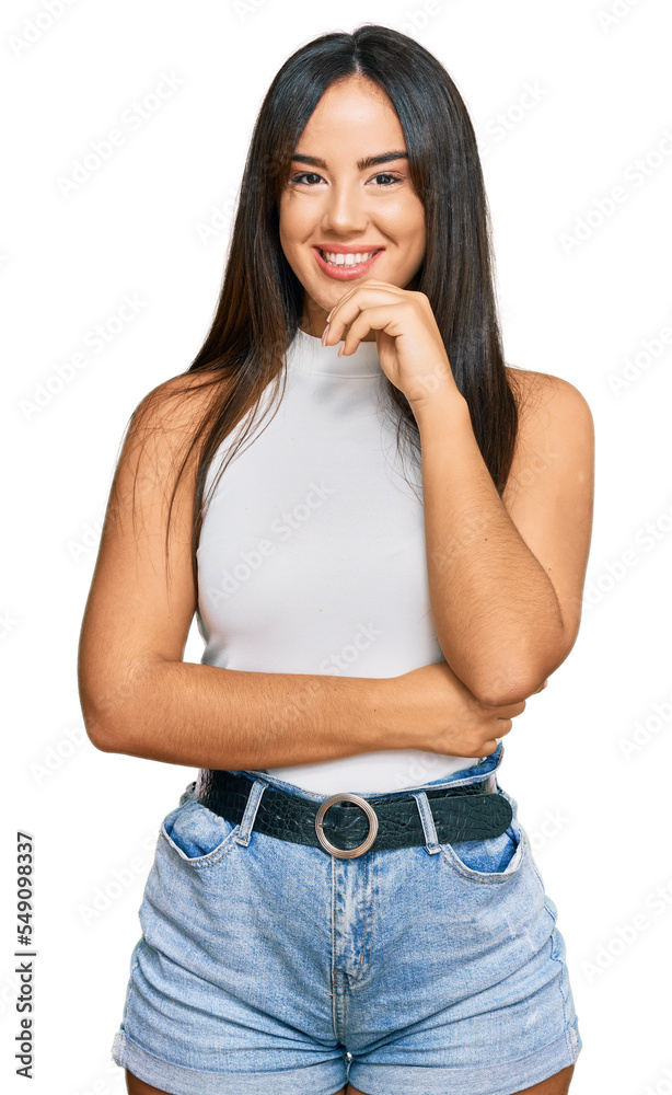 Young beautiful hispanic girl wearing casual clothes looking confident at the camera with smile with crossed arms and hand raised on chin. thinking positive. Young beautiful hispanic girl wearing casual clothes looking confident at the camera with smile with crossed arms and hand raised on chin. thinking positive.