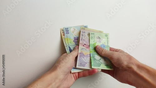 Man hand count Romanian leu (RON) banknotes.
