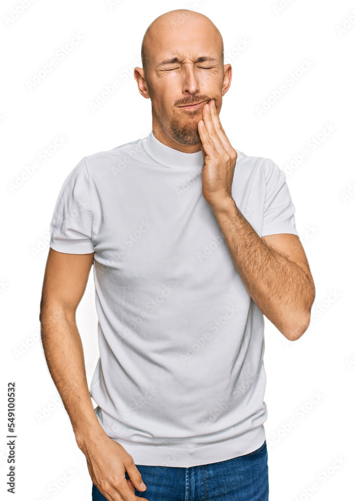 Bald man with beard wearing casual white t shirt touching mouth with hand with painful expression because of toothache or dental illness on teeth. dentist Bald man with beard wearing casual white t shirt touching mouth with hand with painful expression because of toothache or dental illness on teeth. dentist