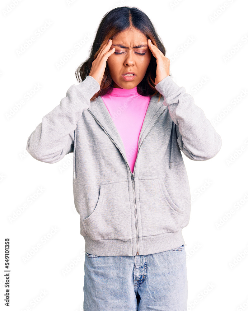 Young beautiful mixed race woman wearing casual sporty clothes with hand on head for pain in head because stress. suffering migraine.