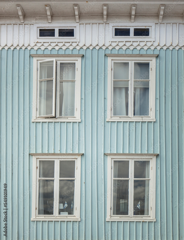 Blue wooden facade with white windows. Traditional wooden facade in Sweden. Light blue facade. Blaue Holzfassade mit weißen Fenstern. Tradtionelle Holzfassade in Schweden. Hellblaue Fassade.