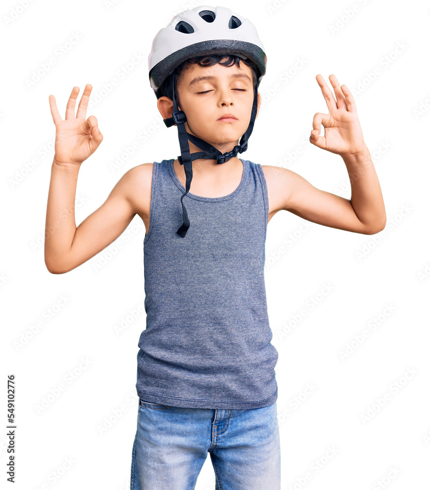 Little cute boy kid wearing bike helmet relax and smiling with eyes closed doing meditation gesture with fingers. yoga concept. Little cute boy kid wearing bike helmet relax and smiling with eyes closed doing meditation gesture with fingers. yoga concept.
