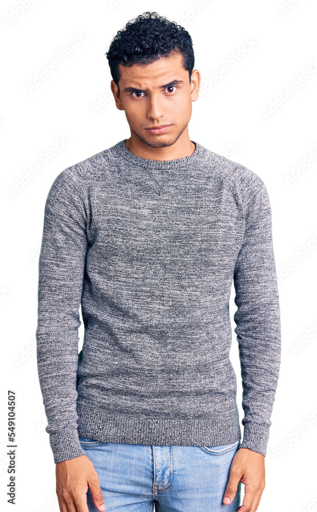 Hispanic handsome young man wearing casual sweater skeptic and nervous, frowning upset because of problem. negative person. Hispanic handsome young man wearing casual sweater skeptic and nervous, frowning upset because of problem. negative person.