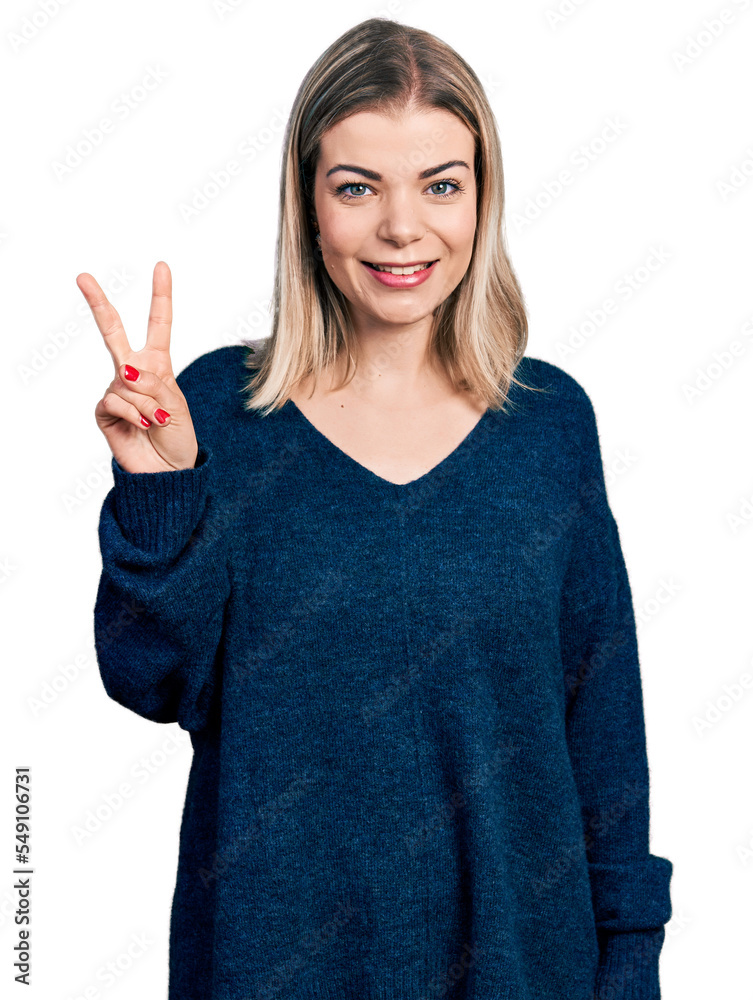 Young blonde woman wearing casual sweater showing and pointing up with fingers number two while smiling confident and happy. Young blonde woman wearing casual sweater showing and pointing up with fingers number two while smiling confident and happy.