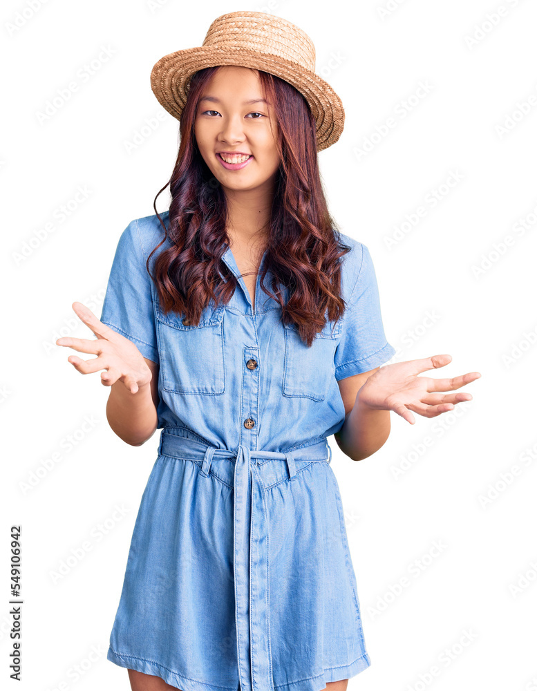 Young beautiful chinese girl wearing summer hat smiling cheerful with open arms as friendly welcome, positive and confident greetings Young beautiful chinese girl wearing summer hat smiling cheerful with open arms as friendly welcome, positive and confident greetings