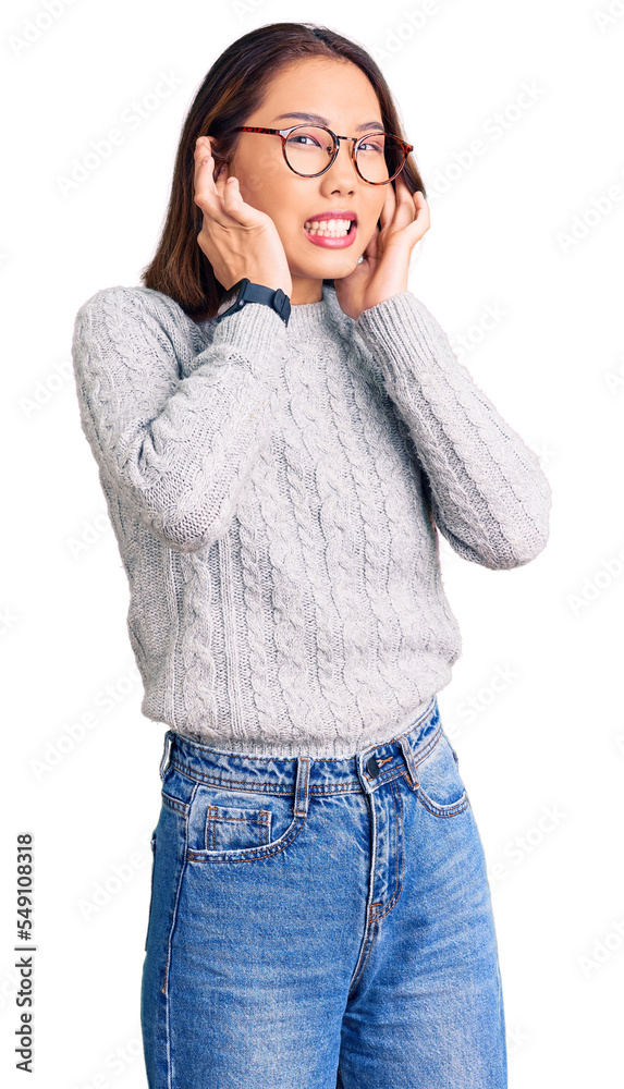Young beautiful chinese girl wearing casual clothes covering ears with fingers with annoyed expression for the noise of loud music. deaf concept. Young beautiful chinese girl wearing casual clothes covering ears with fingers with annoyed expression for the noise of loud music. deaf concept.