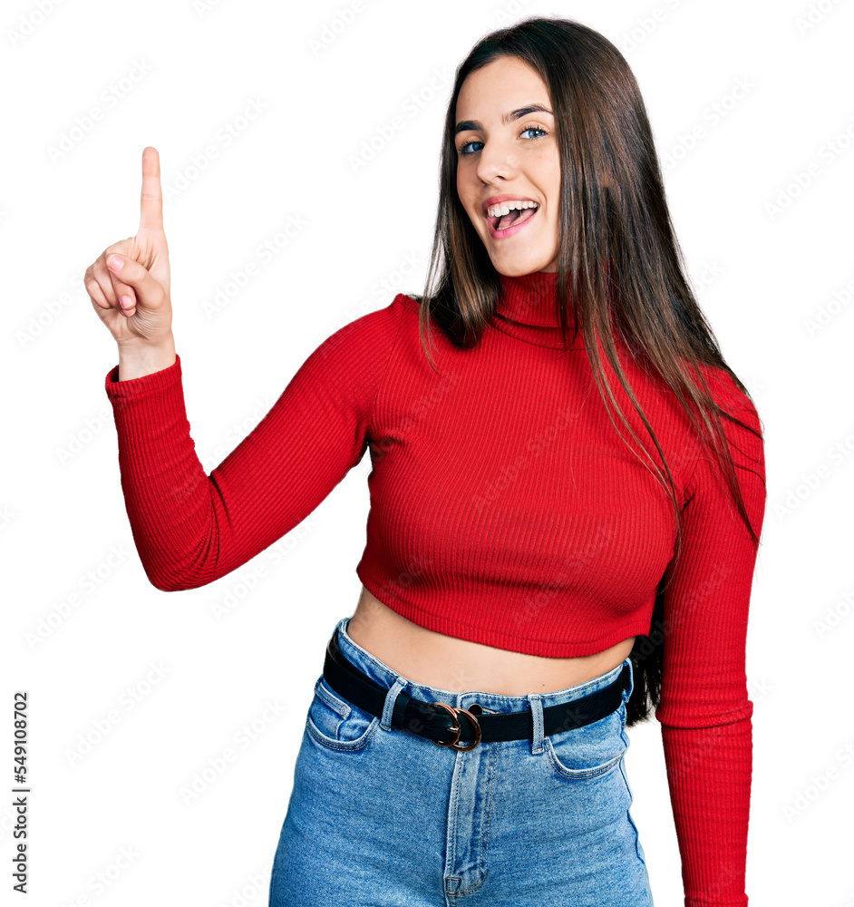 Young brunette teenager wearing red turtleneck sweater pointing finger up with successful idea. exited and happy. number one. Young brunette teenager wearing red turtleneck sweater pointing finger up with successful idea. exited and happy. number one.