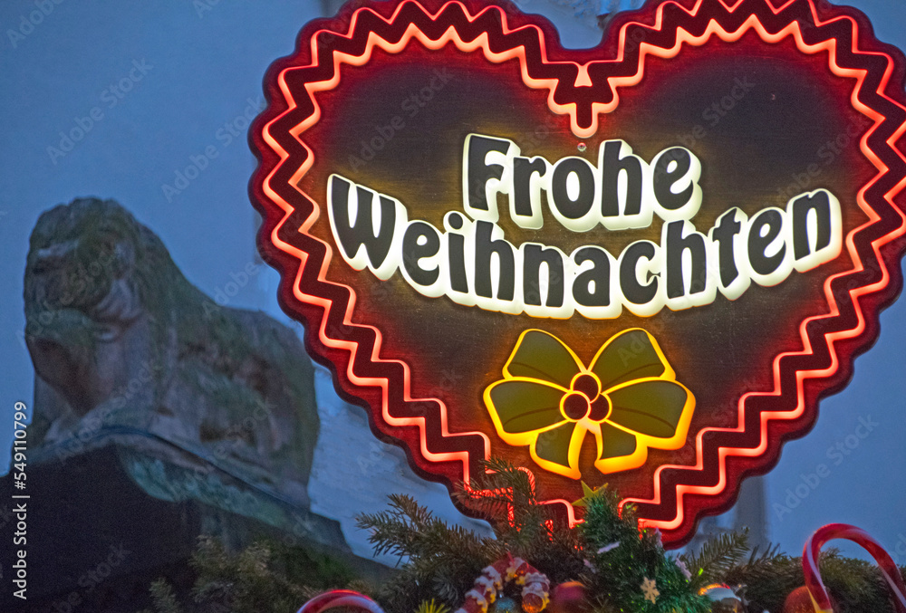 Beleuchteter Schriftzug "Frohe Weihnachten" und römische Skulptur