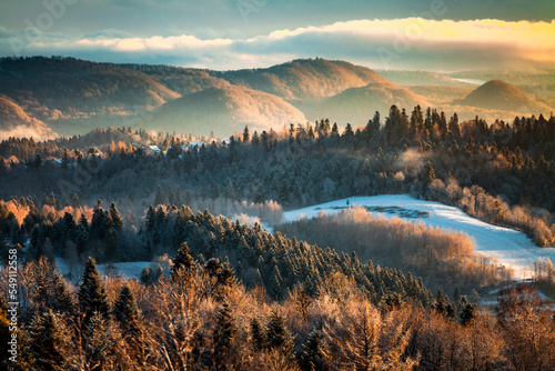 Fototapeta Piękne góry porośnięte lasem w delikatnej porannej mgle oświetlonej światłem wschodzącego słońca, Bieszczady, Polska