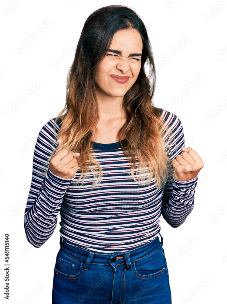 Beautiful hispanic woman wearing casual striped shirt excited for success with arms raised and eyes closed celebrating victory smiling. winner concept. Beautiful hispanic woman wearing casual striped shirt excited for success with arms raised and eyes closed celebrating victory smiling. winner concept.