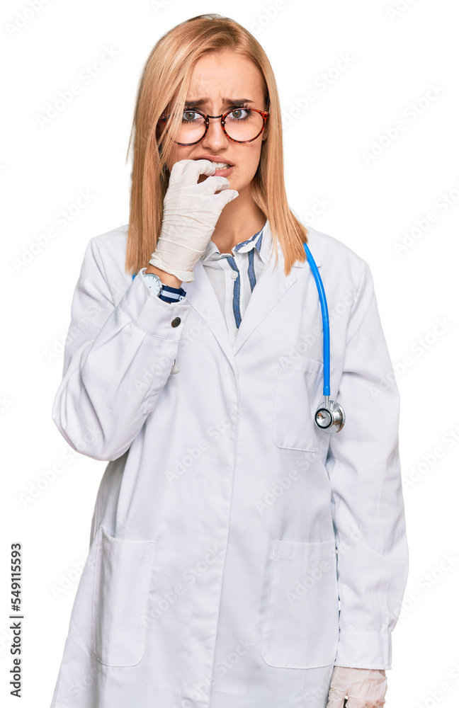 Beautiful caucasian woman wearing doctor uniform and stethoscope looking stressed and nervous with hands on mouth biting nails. anxiety problem. Beautiful caucasian woman wearing doctor uniform and stethoscope looking stressed and nervous with hands on mouth biting nails. anxiety problem.