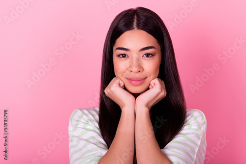 Photo of satisfied glad young thai person arms touch face chin look camera isolated on pink color background