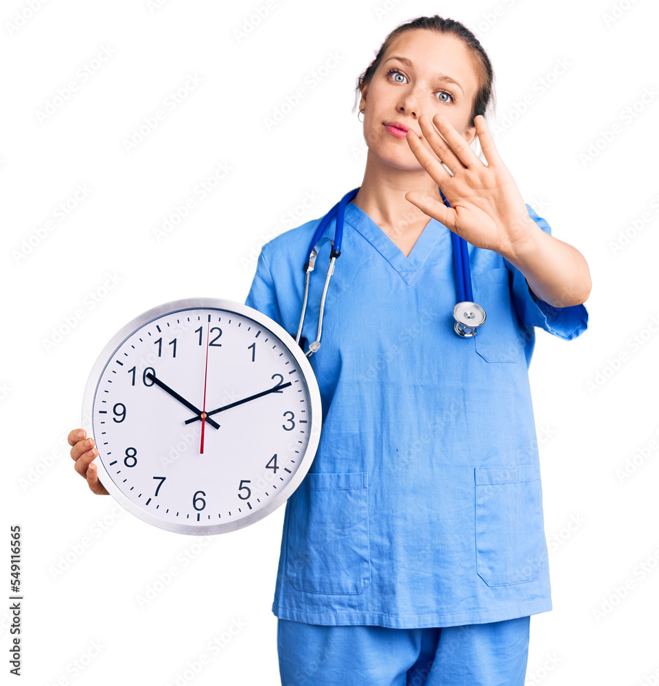 Young beautiful blonde woman wearing doctor uniform and stethoscope with open hand doing stop sign with serious and confident expression, defense gesture Young beautiful blonde woman wearing doctor uniform and stethoscope with open hand doing stop sign with serious and confident expression, defense gesture
