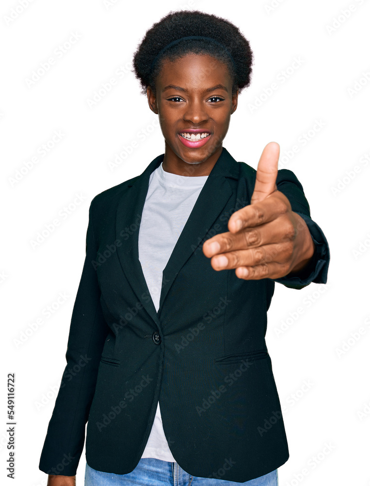 Young african american girl wearing business clothes smiling friendly offering handshake as greeting and welcoming. successful business.