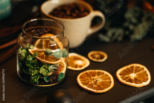 cup with coffee beans on the table with dry oranges