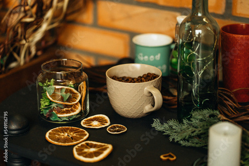 cup with coffee beans on the table with dry oranges