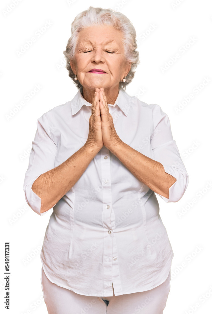 Senior grey-haired woman wearing casual clothes begging and praying with hands together with hope expression on face very emotional and worried. begging. Senior grey-haired woman wearing casual clothes begging and praying with hands together with hope expression on face very emotional and worried. begging.