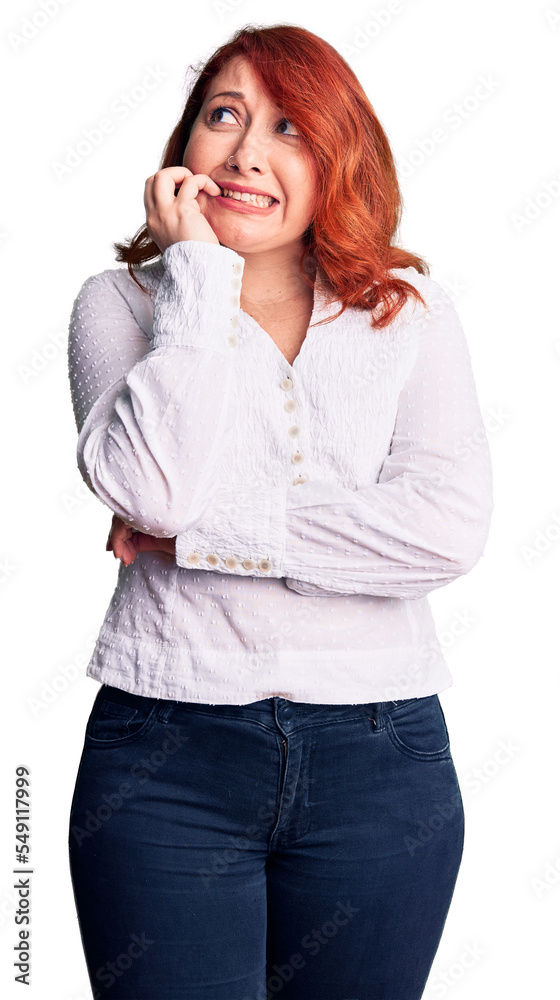 Young beautiful redhead woman wearing casual shirt looking stressed and nervous with hands on mouth biting nails. anxiety problem. Young beautiful redhead woman wearing casual shirt looking stressed and nervous with hands on mouth biting nails. anxiety problem.