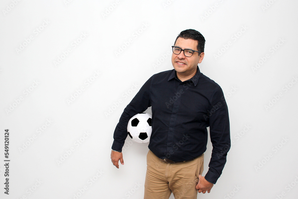 Latino adult office man plays with a soccer ball very excited that he is going to see the game and wants to see his team win Latino adult office man plays with a soccer ball very excited that he is going to see the game and wants to see his team win