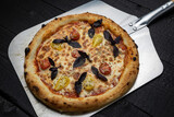 tasty pizza with cheese and vegetables on a wooden dark table
