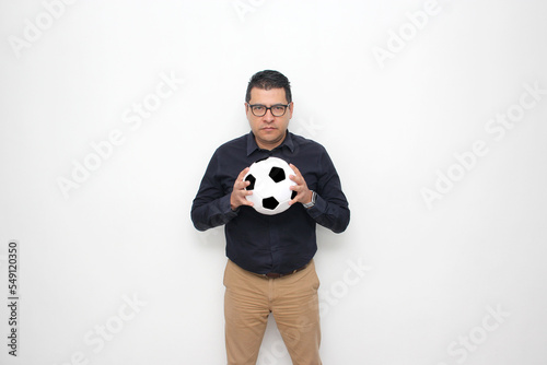 Fototapeta Naklejka Na Ścianę i Meble -  Latino adult office man plays with a soccer ball very excited that he is going to see the game and wants to see his team win