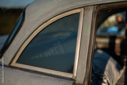 Rear quoter panel of a classic car with a view of interior through the window. photo