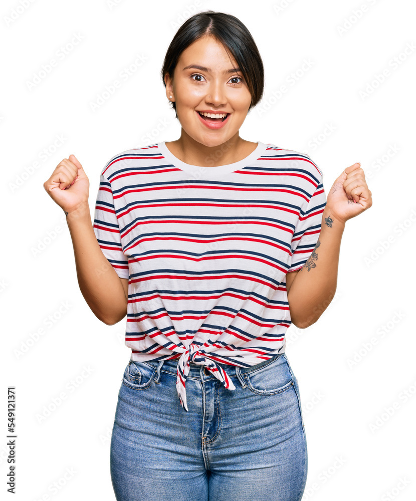 Beautiful young woman with short hair wearing casual clothes celebrating surprised and amazed for success with arms raised and open eyes. winner concept. Beautiful young woman with short hair wearing casual clothes celebrating surprised and amazed for success with arms raised and open eyes. winner concept.