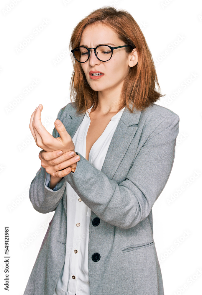 Young caucasian woman wearing business style and glasses suffering pain on hands and fingers, arthritis inflammation Young caucasian woman wearing business style and glasses suffering pain on hands and fingers, arthritis inflammation
