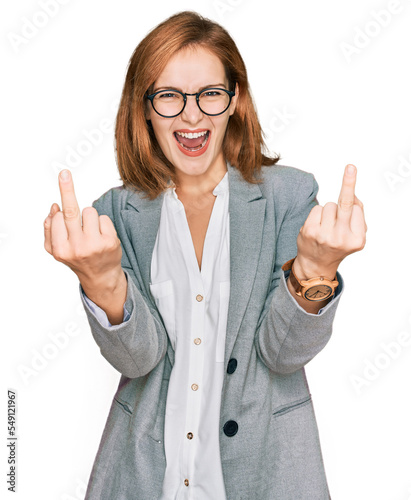 Quadro su tela Young caucasian woman wearing business style and glasses showing middle finger doing fuck you bad expression, provocation and rude attitude