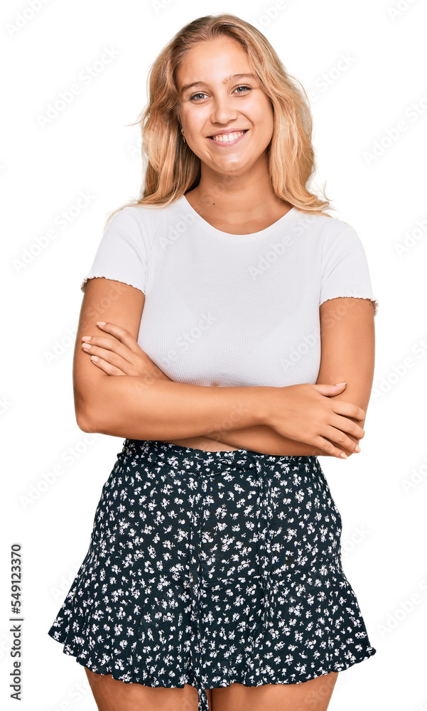 Young blonde girl wearing casual white tshirt happy face smiling with crossed arms looking at the camera. positive person.