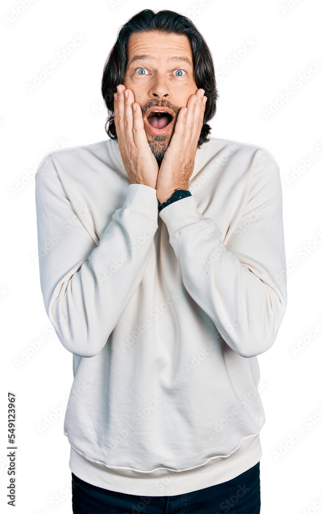 Middle age caucasian man wearing casual clothes afraid and shocked, surprise and amazed expression with hands on face