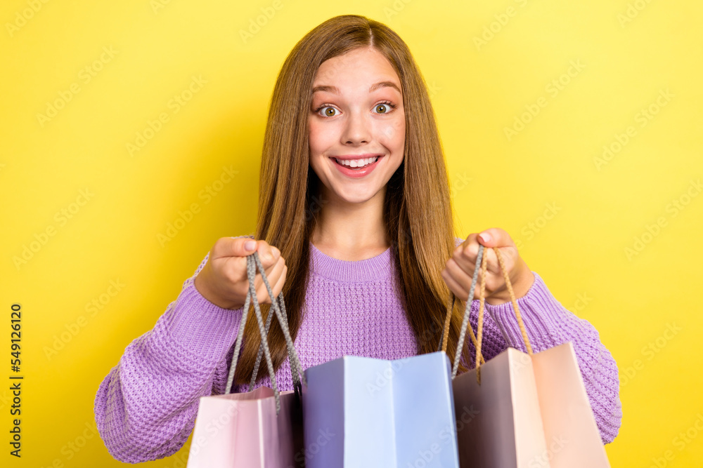 Closeup portrait photo of positive cute dreamy girlish schoolgirl wear warm knit sweater hold bags shopping mall black friday isolated on yellow color background
