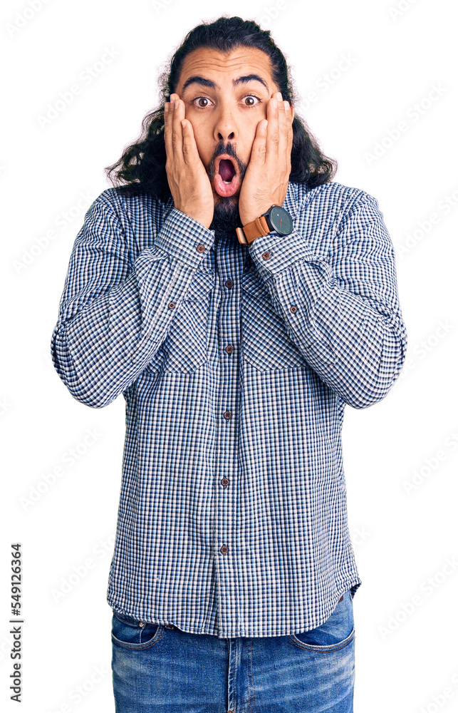 Young arab man wearing casual clothes afraid and shocked, surprise and amazed expression with hands on face Young arab man wearing casual clothes afraid and shocked, surprise and amazed expression with hands on face